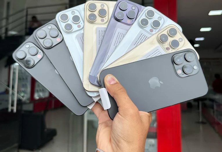 iPhone de exhibición en abanico, con el local de Aló! Central Móvil al fondo