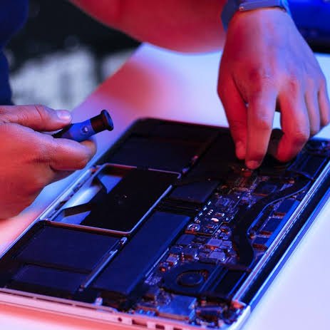Técnico reparando la placa de un iPhone en Aló! Central Móvil